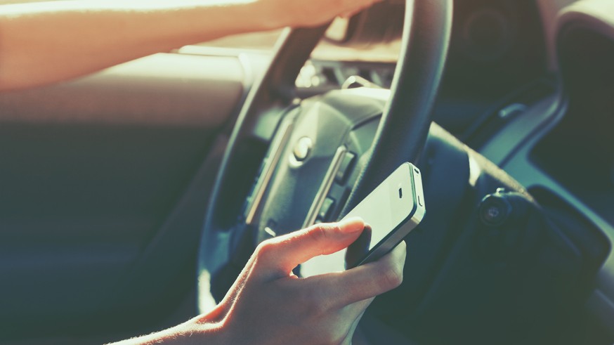 girls hand using smart phone while car driving